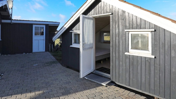 A small, single-story building with a sloped roof, a door, and a window. - 8 Person Holiday Home in Harboore (Harboore)