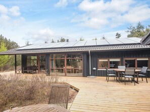 A modern building with large windows, a deck, and outdoor seating. - 5 Star Holiday Home in Fjerritslev (Fjerritslev)