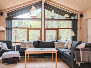A cozy living room with a large window, wooden ceiling, and a sofa set. - 5 Star Holiday Home in Fjerritslev (Fjerritslev)