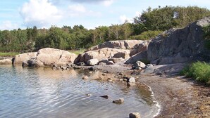 A natural landscape with a body of water, large rocks, and a forested area. - Holiday Home in KÃ¥llekÃ¤rr (Kållekärr)