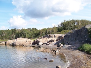 A natural landscape with a body of water, large rocks, and a forested area. - Holiday Home in KÃ¥llekÃ¤rr (Kållekärr)