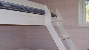 A bunk bed with a ladder, a window with a view of trees, and a wooden wall. - Holiday Home in KÃ¥llekÃ¤rr (Kållekärr)