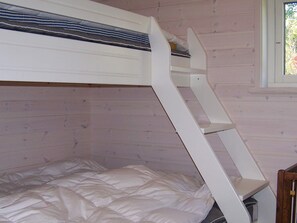 A bunk bed with a ladder, a window with a view of trees, and a wooden wall. - Holiday Home in KÃ¥llekÃ¤rr (Kållekärr)