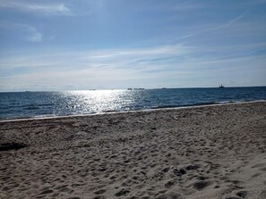 A sandy beach with a clear sky and calm sea. - 4 Person Holiday Home in Rodby (Rodby)