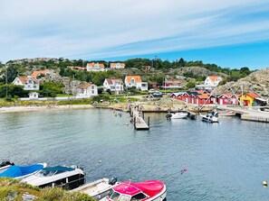 A coastal village with houses, a pier, and boats. - 4 Person Holiday Home in Ronnang (Roennaeng)