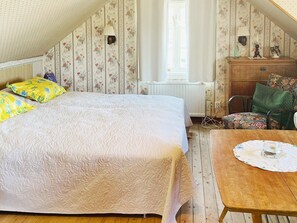 A bedroom with a bed, a wooden dresser, a chair, and a table. - 4 Person Holiday Home in Ronnang (Roennaeng)