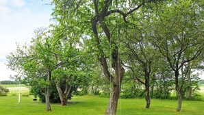 A grassy area with trees and a wooden swing. - Holiday Home in Vara (Vara)