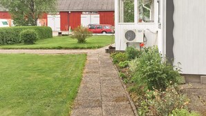 A pathway leading to a white building with a red barn in the background. - Holiday Home in Vara (Vara)