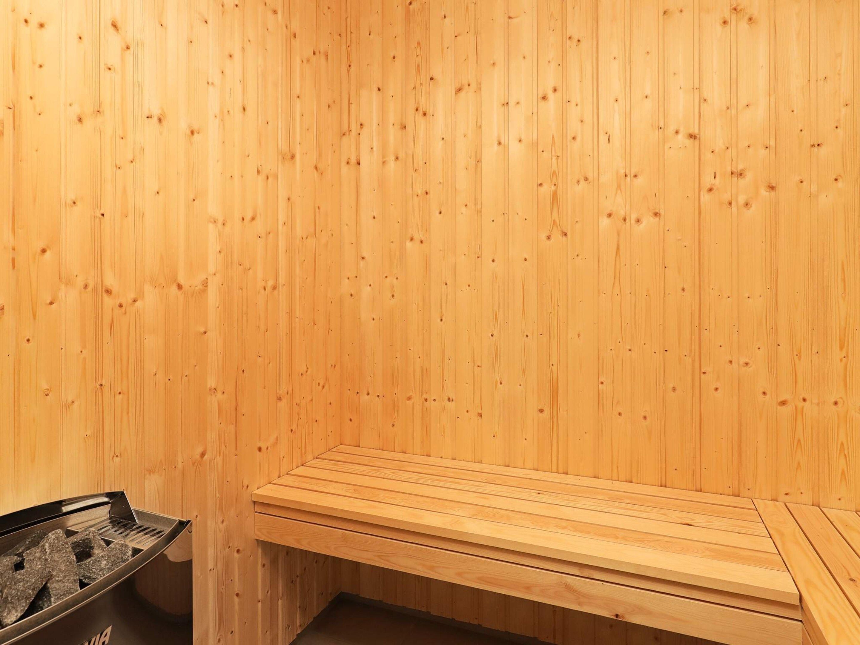 Un sauna avec des murs et des bancs en bois.