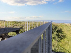 A wooden deck with a metal railing overlooking a coastal landscape. - 4 Star Holiday Home in Hirtshals (Hirtshals)