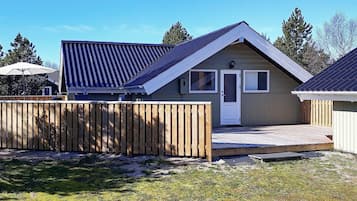 A single-story building with a pitched roof, a front door, and a small porch area.