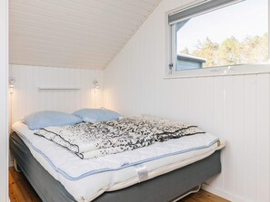 A bedroom with a bed, two wall-mounted lights, a window, and a view of trees outside. - Lovely Holiday Home in Ã…lbÃ¦k near Sea (Aalbaek)
