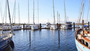 A marina with multiple sailboats docked at wooden piers. - Holiday Home in Wendtorf (Wendtorf)