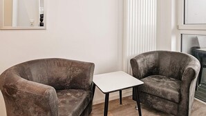 A room with two armchairs and a small white table. - Holiday Home in Wendtorf (Wendtorf)