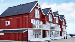 A red building with white balconies and a black roof. - Seaside Escape in Bagenkop - By Traum Ferienwohnungen (Sydlangeland)