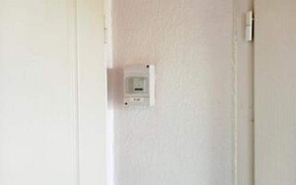 A white wall with a thermostat and a light switch. - 12 Person Holiday Home in Bredebro (Bredebro)