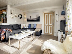 A modern living room with a grey sofa, a white coffee table, and a large window. - 6 Person Holiday Home in Lokken (Lokken)