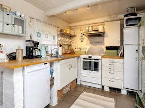 A compact kitchen with white cabinetry, a built-in oven, a microwave, and a sink. - 6 Person Holiday Home in Lokken (Lokken)