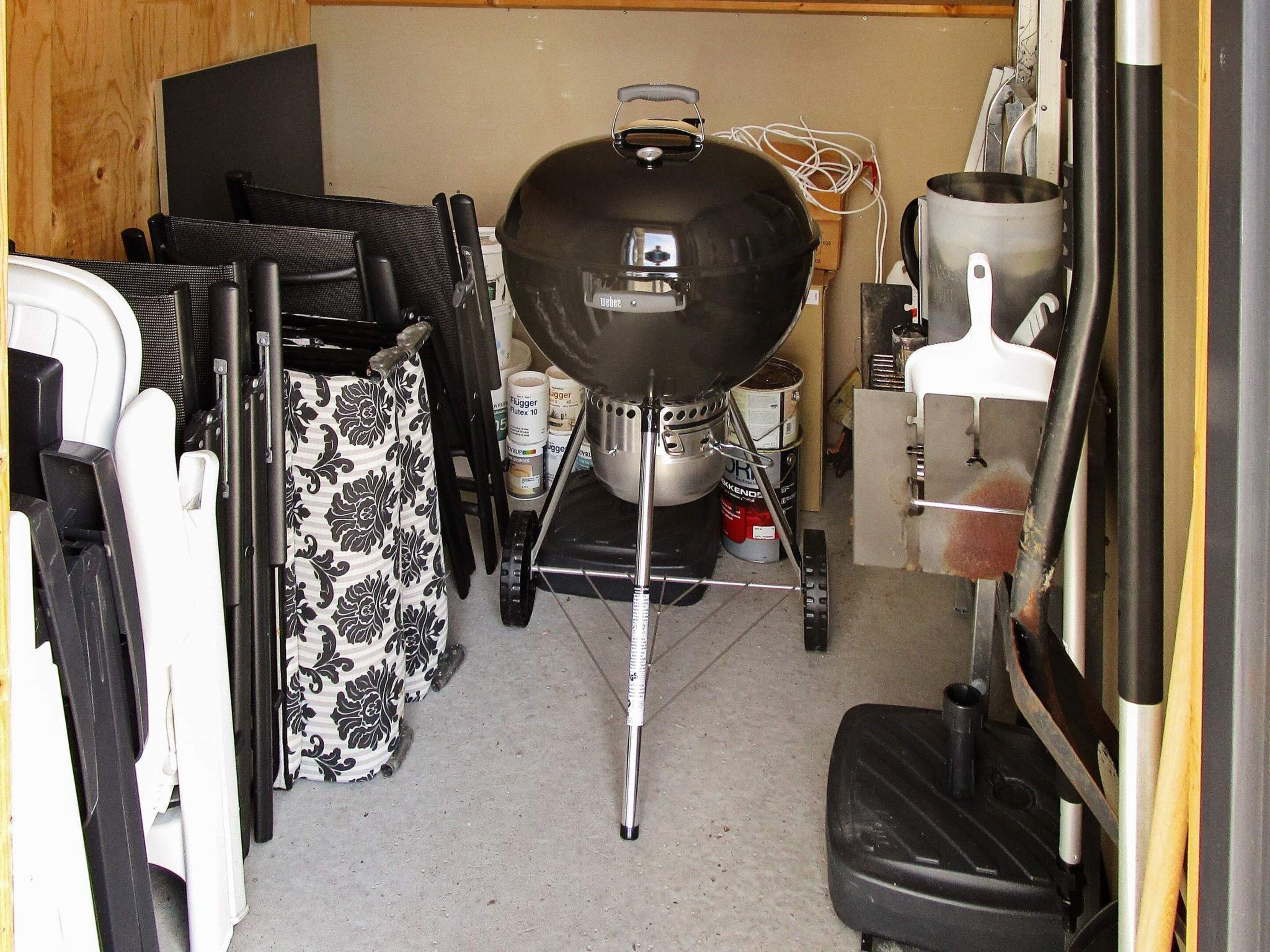 A compact kitchen with a barbecue grill, a sink, and a variety of kitchen utensils and appliances.