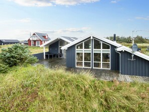 Una casa moderna con un'ampia vetrata e un tetto spiovente.