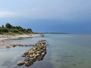 A rocky shoreline with clear water and a distant view of land. - 5 Star Holiday Home in Bogense (Bogense)