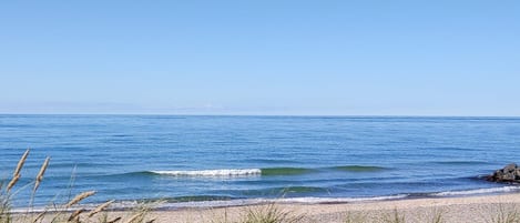 Una spiaggia con acque cristalline e una battigia sabbiosa.