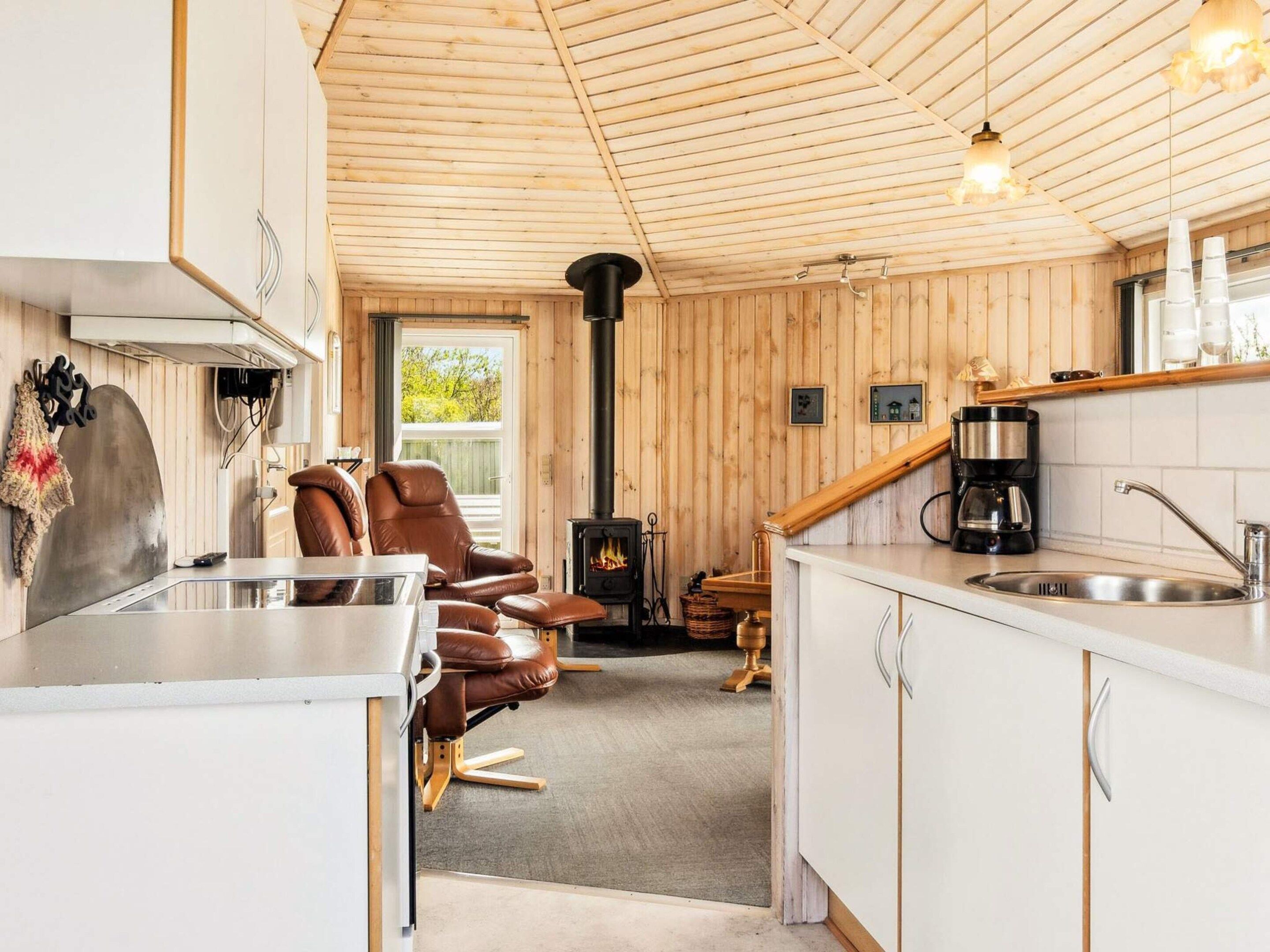 A cozy cabin interior with a kitchen, dining area, and a fireplace.