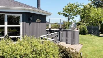 Una casa con un área exterior cubierta, una chimenea y un letrero que dice 'Slottet'.