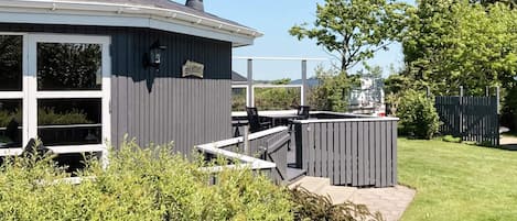Una casa con un área exterior cubierta, una chimenea y un letrero que dice 'Slottet'.