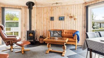Una habitación acogedora con detalles de madera, una chimenea, muebles de cuero y una mesa de comedor.