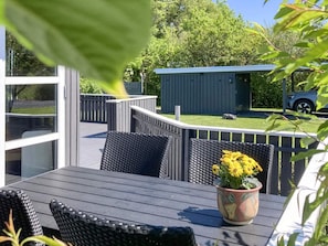A deck with outdoor furniture, a potted plant, and a shed in the background. - 4 Person Holiday Home in Vinderup (Vinderup)