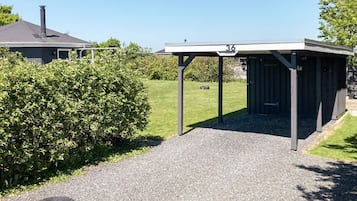 A covered outdoor area with a gravel path leading to a building marked with the number 36.
