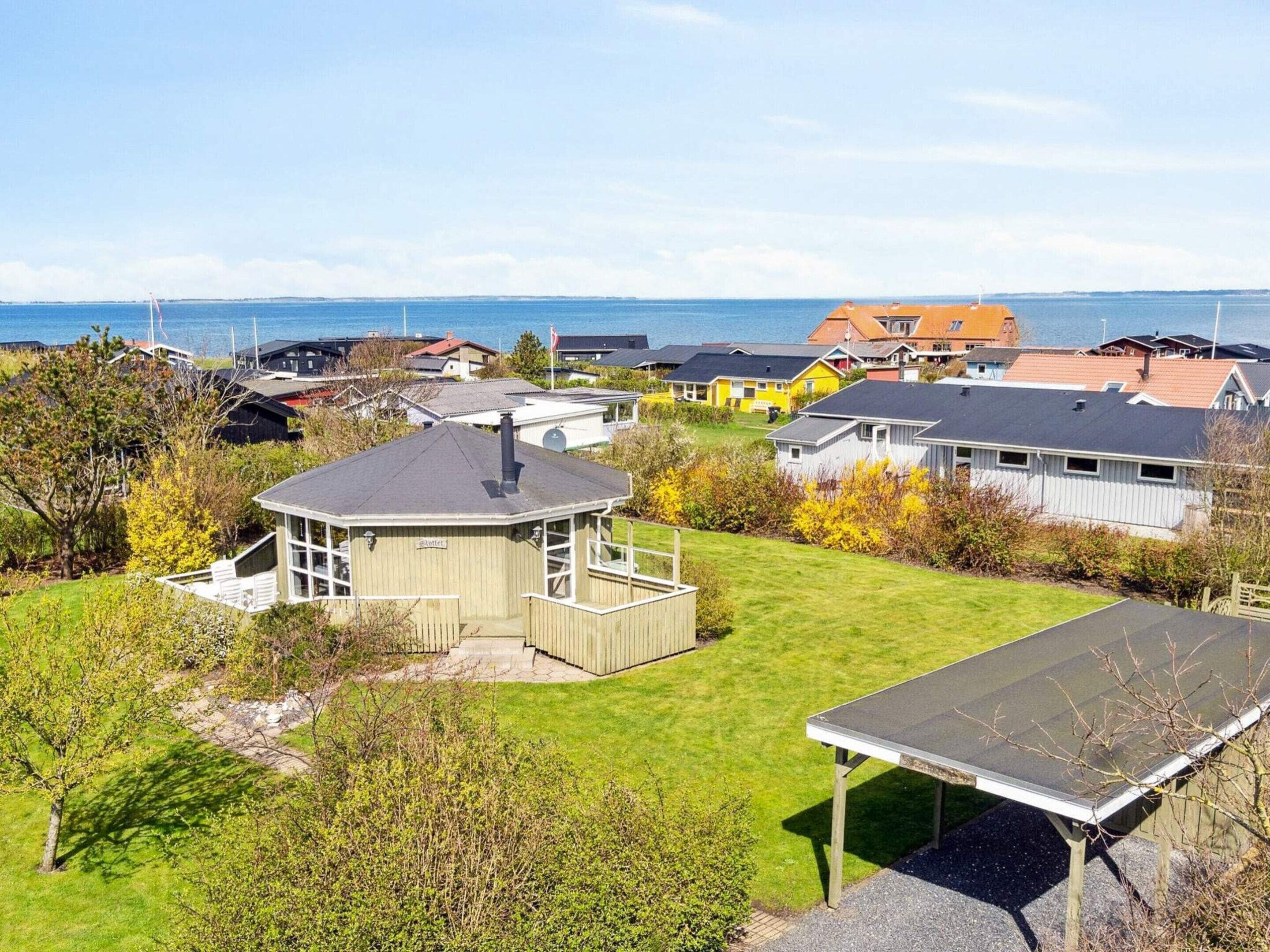 Un barrio residencial con casas, un pequeño pabellón y vista al mar.