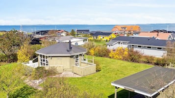 Un barrio residencial con casas, un pequeño pabellón y vista al mar.