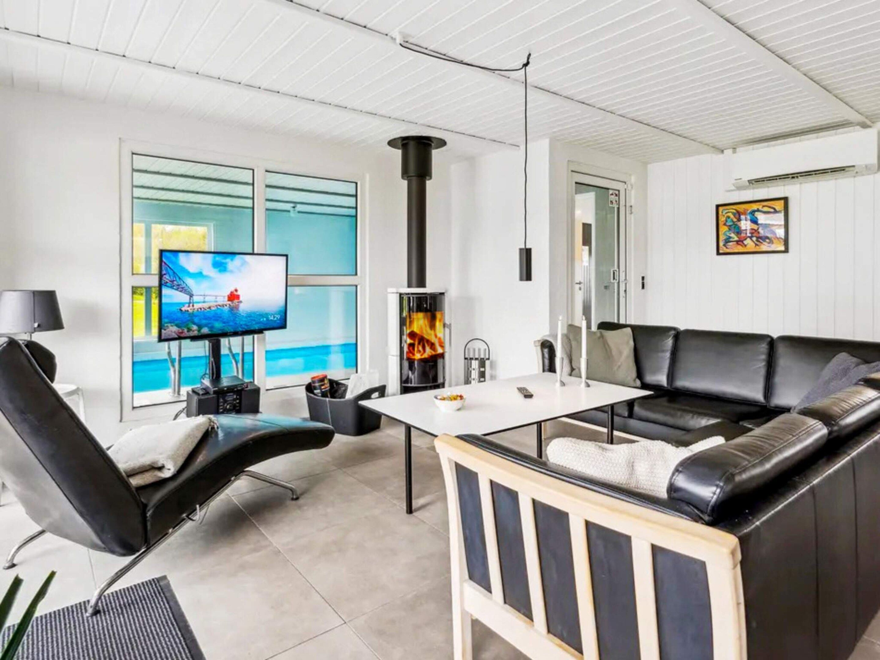 A modern living room with a fireplace, a television, and a sofa.