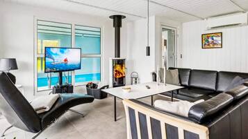 A modern living room with a fireplace, a television, and a sofa.