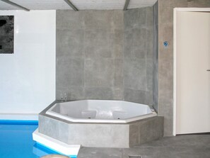 Un bany modern amb una banyera autònoma, parets revestides i una zona de dutxa.
