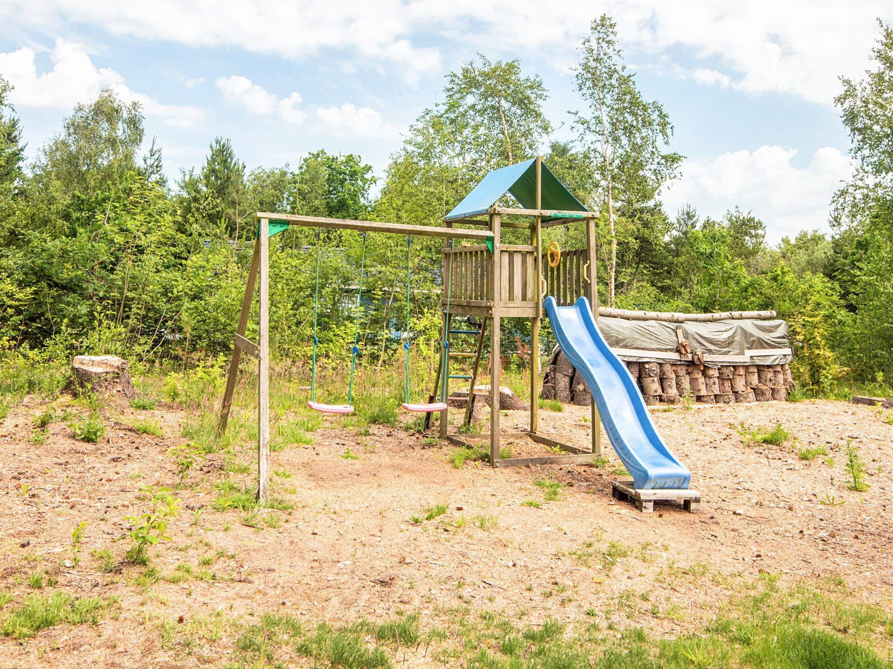 A playground with a swing set, slide, and climbing structure.