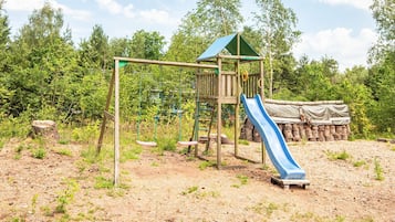 A playground with a swing set, slide, and climbing structure.