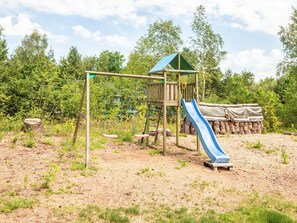 A playground with a swing set, slide, and climbing structure.