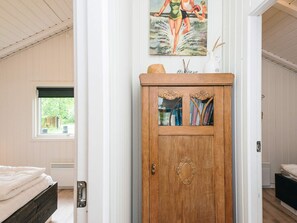 A room with a wooden cabinet, a bed, and a window with a view of greenery. - Fascinating Holiday Home in Norre Nebel near Sea (Norre Nebel)