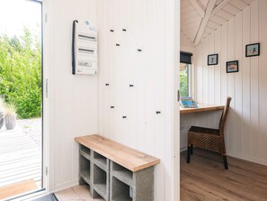 A room with a bench, a wall-mounted electrical panel, a window with a view of greenery, and a chair. - Fascinating Holiday Home in Norre Nebel near Sea (Norre Nebel)