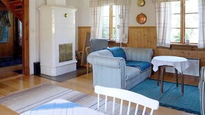 A cozy living room with a fireplace, striped sofa, and a dining table. - 5 Person Holiday Home in Nordingra-by Traum (Nordingra)