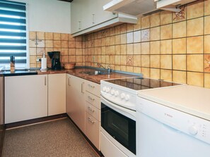 Une cuisine équipée d’un four Bosch, d’un évier et de placards.
