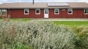 A red building with a flat roof, a door, and windows. - 10 Person Holiday Home in Harboore (Harboore)