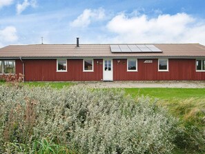 A red building with a flat roof, a door, and windows. - 10 Person Holiday Home in Harboore (Harboore)