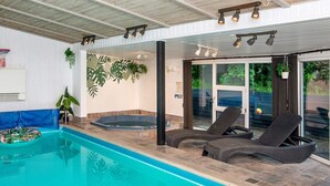 An indoor swimming pool with a hot tub, lounge chairs, and a basketball hoop. - Refined Holiday Home in Glesborg near Sea (Glesborg)