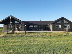 A modern two-story building with a covered patio area and a playground. - 5 Star Holiday Home in Stege (Stege)