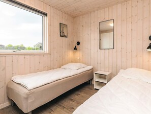 A single bed with a white mattress and a wooden floor. - 5 Star Holiday Home in Stege (Stege)