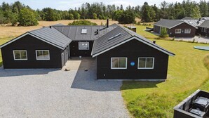 A two-story building with a gravel driveway and a small lawn area. - Luxury Retreat in Albaek (Aalbaek)